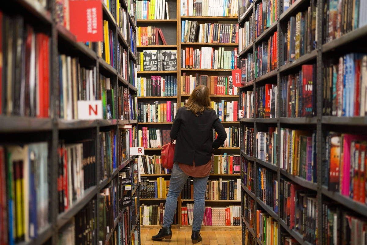 woman browsing plentiful shelves in bookstore